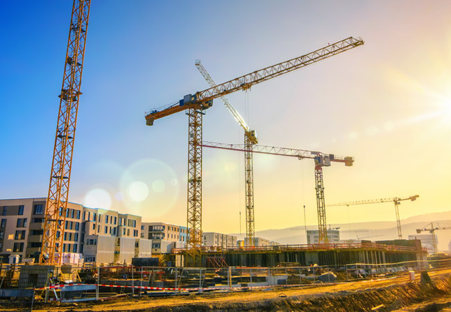 Projektmanagement am Beispiel eines Hochhauses in der Bauhphase mit Kran und Gerüst.